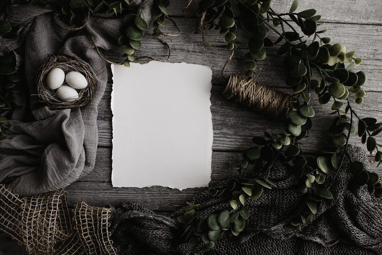 Minimalistische paastafel met wit servies en pastelkleuren.